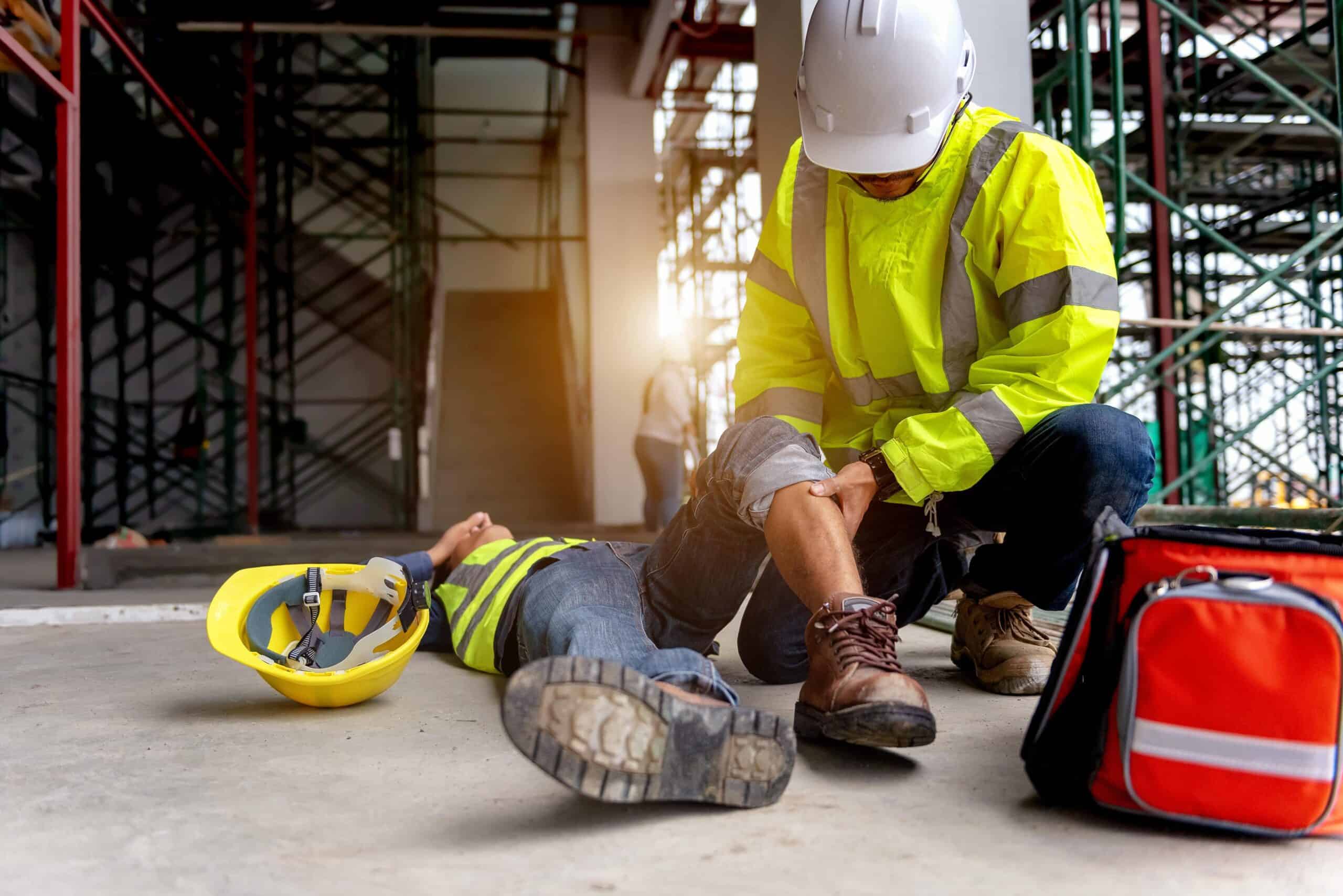 Link Resources first aid and CPR training worker assisting injured colleague at construction site