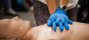 A person wearing blue nitrile gloves is handling a piece of machinery or equipment.